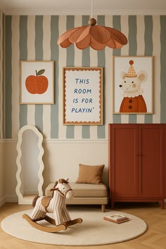 Sage-and-cream striped playroom wall with an apple print, a rust wardrobe, a scalloped pendant light, and a wooden rocking horse